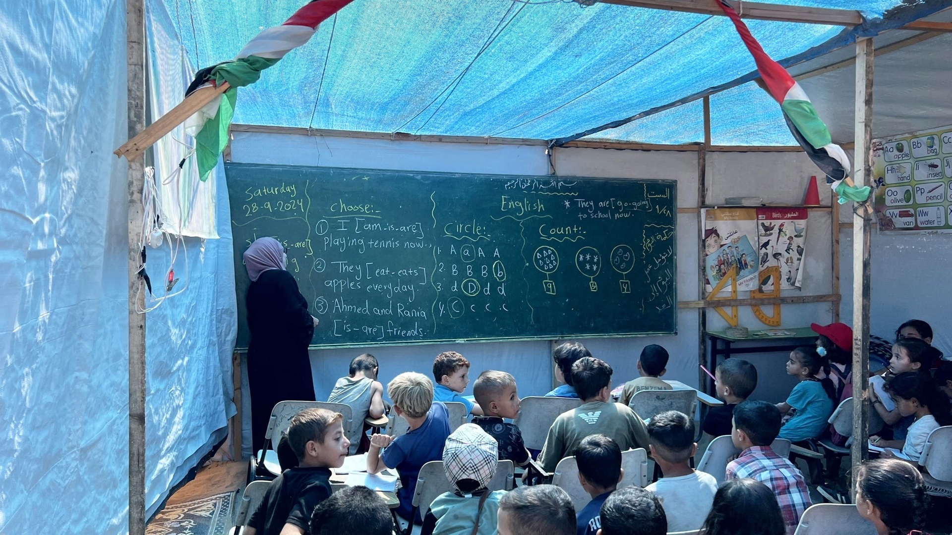 Students in Gaza attending classes in a temporary school setting